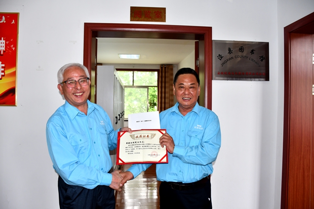 公司工會主席許鋒（右）向公司監(jiān)事會主席、捐書人胡夏生頒發(fā)《收藏證書》